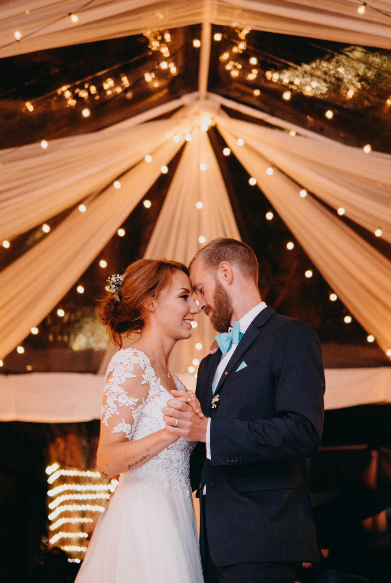 A couple dancing together beneath the lights